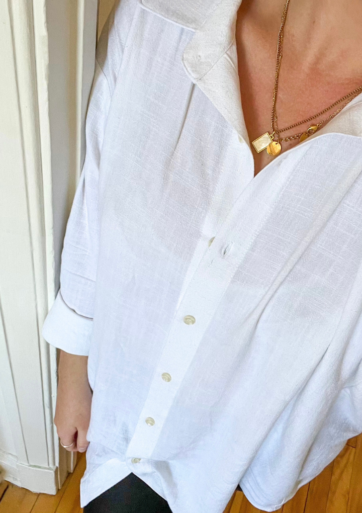 A selfie of a woman wearing the staple linen blouse in the color white