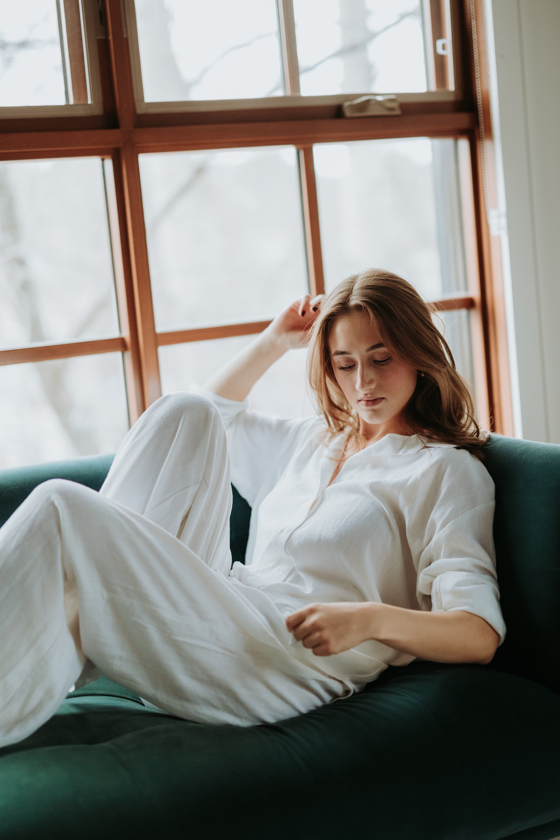 a woman is sitting on a couch and wearing the white staple linen pants. The pants are not see-through at all when worn with beige underwear